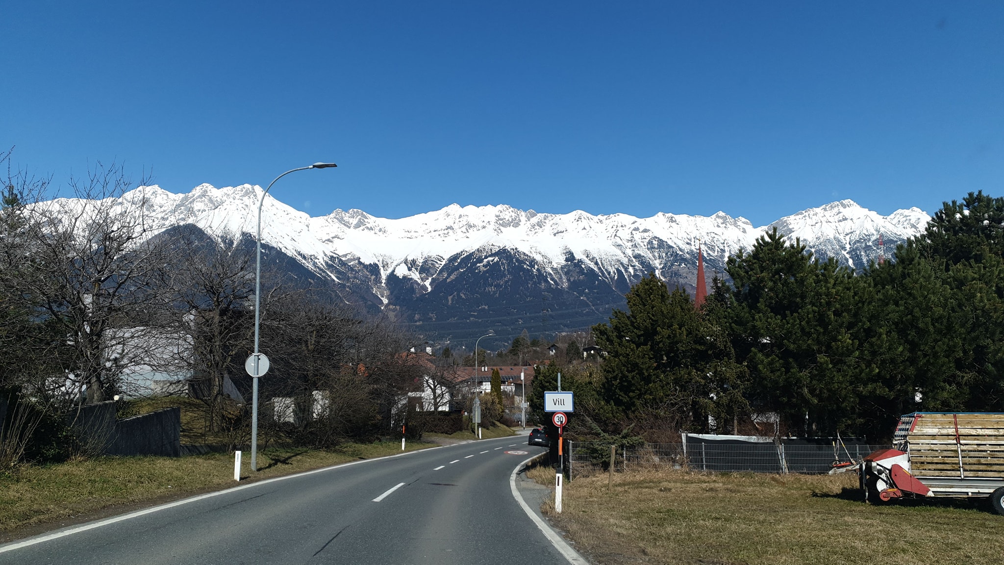 Snow-covered mountains above a village road