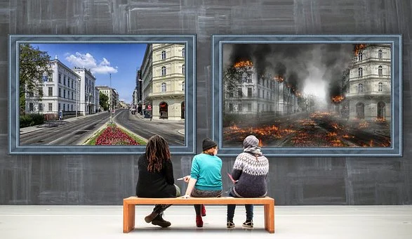 People looking at contrasting visions of a peaceful city and a city in flames