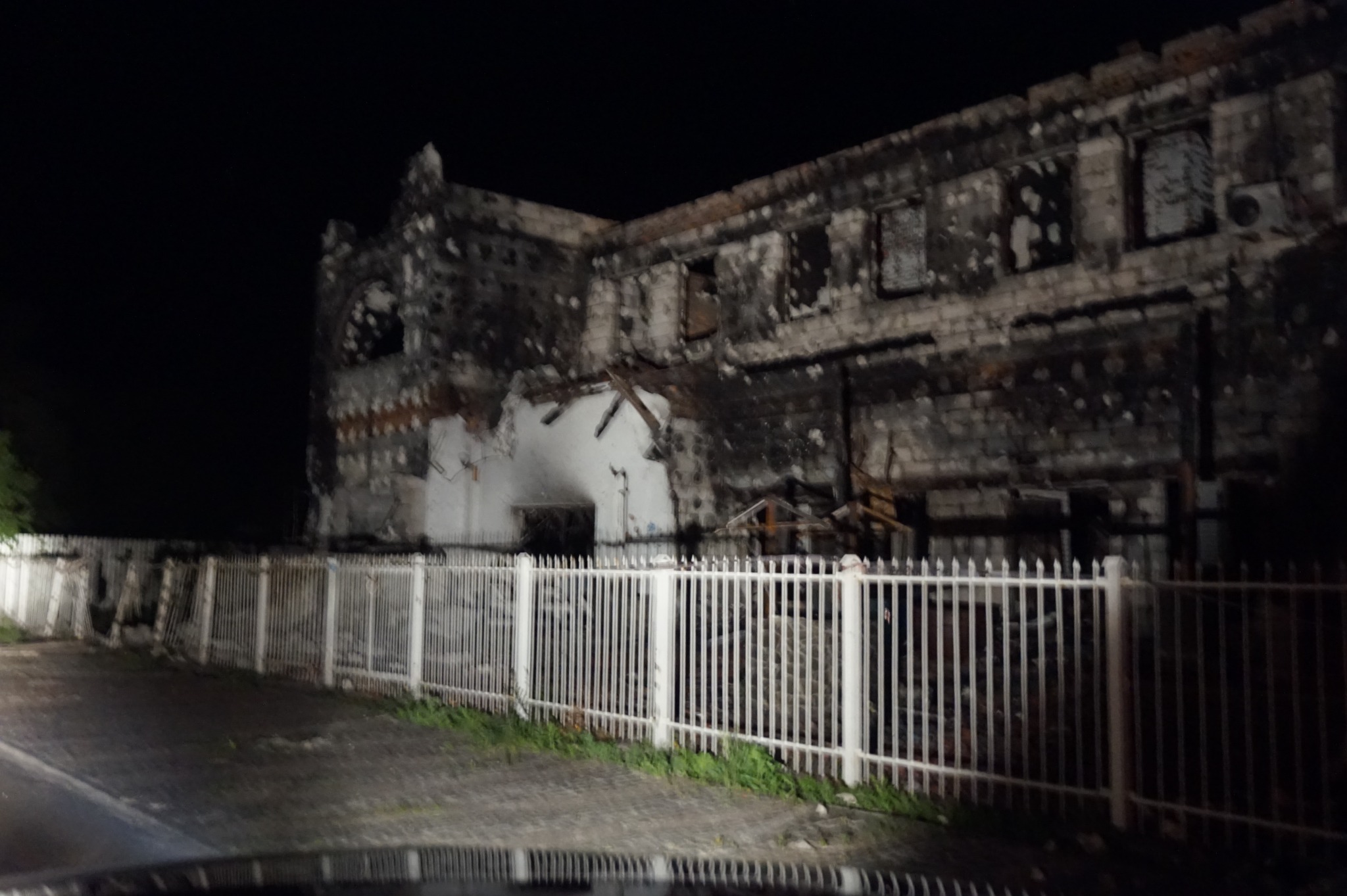 Night-time photograph of the damaged White House hotel outside Kyiv