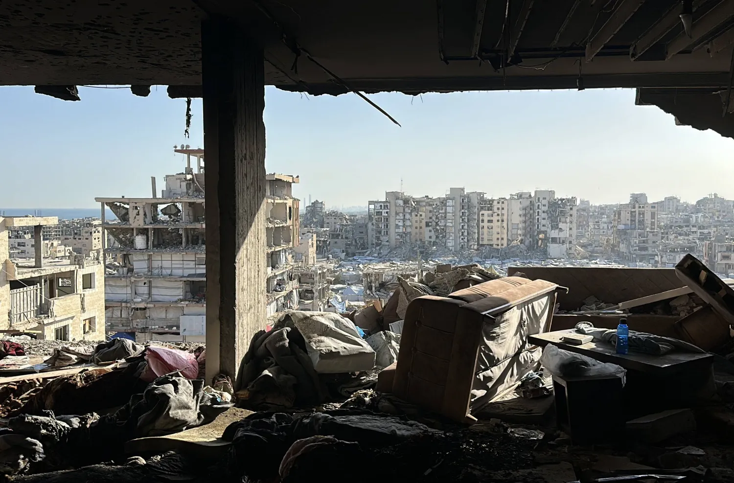 View from inside a damaged home across ruined buildings in Gaza City