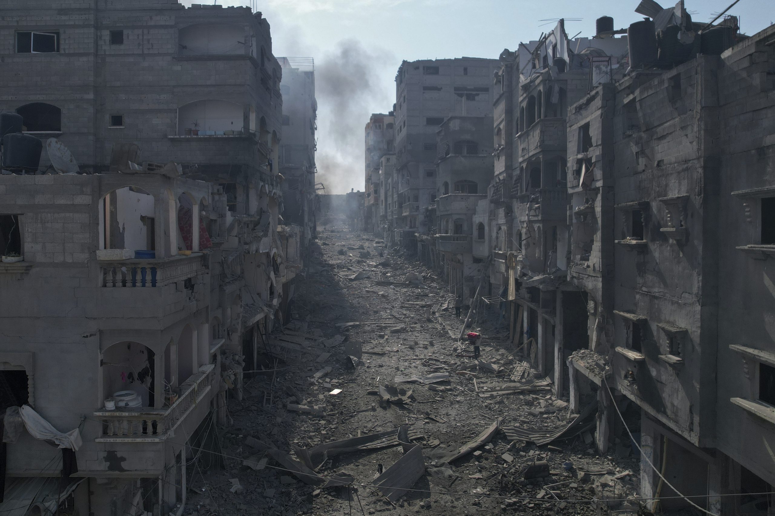 Damaged buildings and rubble along a street in Jabalia