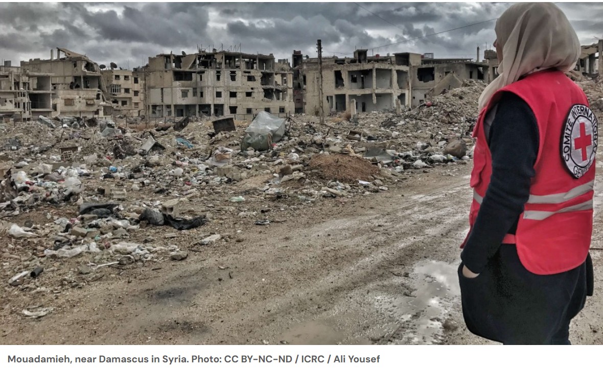 ICRC worker overlooking damaged buildings in Mouadamieh near Damascus, Syria