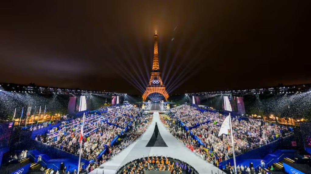 Crowds and illuminated Eiffel Tower at night in Paris