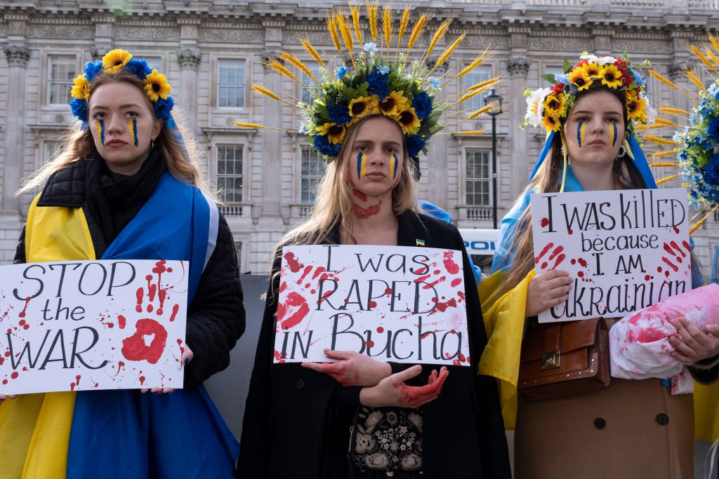 Demonstrators wearing Ukrainian colours and holding anti-war signs